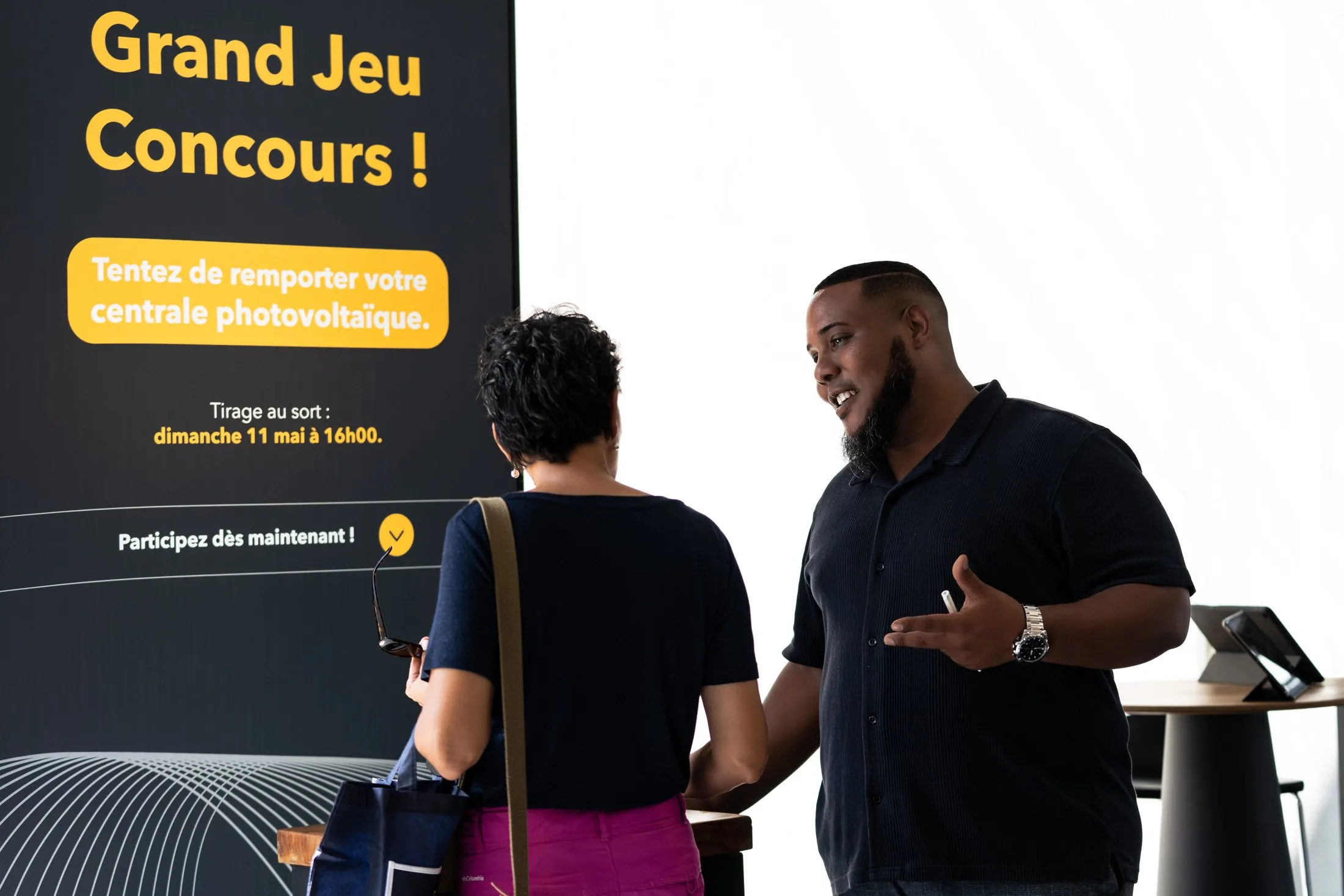 Stand Austral Groupe Énergie « N°1 du photovoltaïque résidentiel à La Réunion » — conseiller présentant le Grand Jeu Concours à une visiteuse