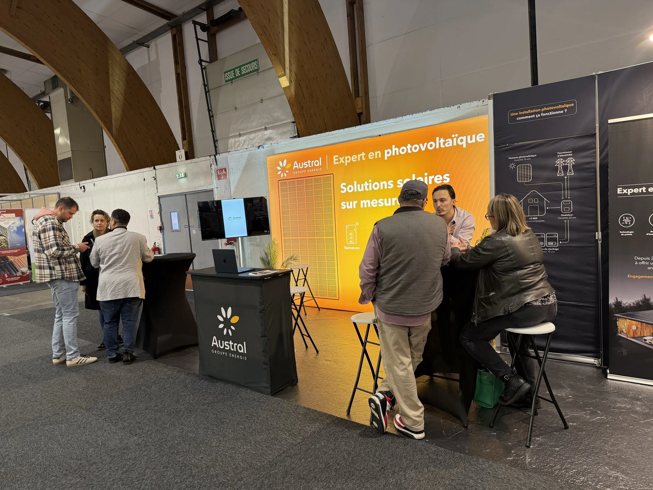 Stand Austral Groupe Énergie « Expert en photovoltaïque » au salon Viving — rendez-vous conseil devant le mur lumineux et le totem