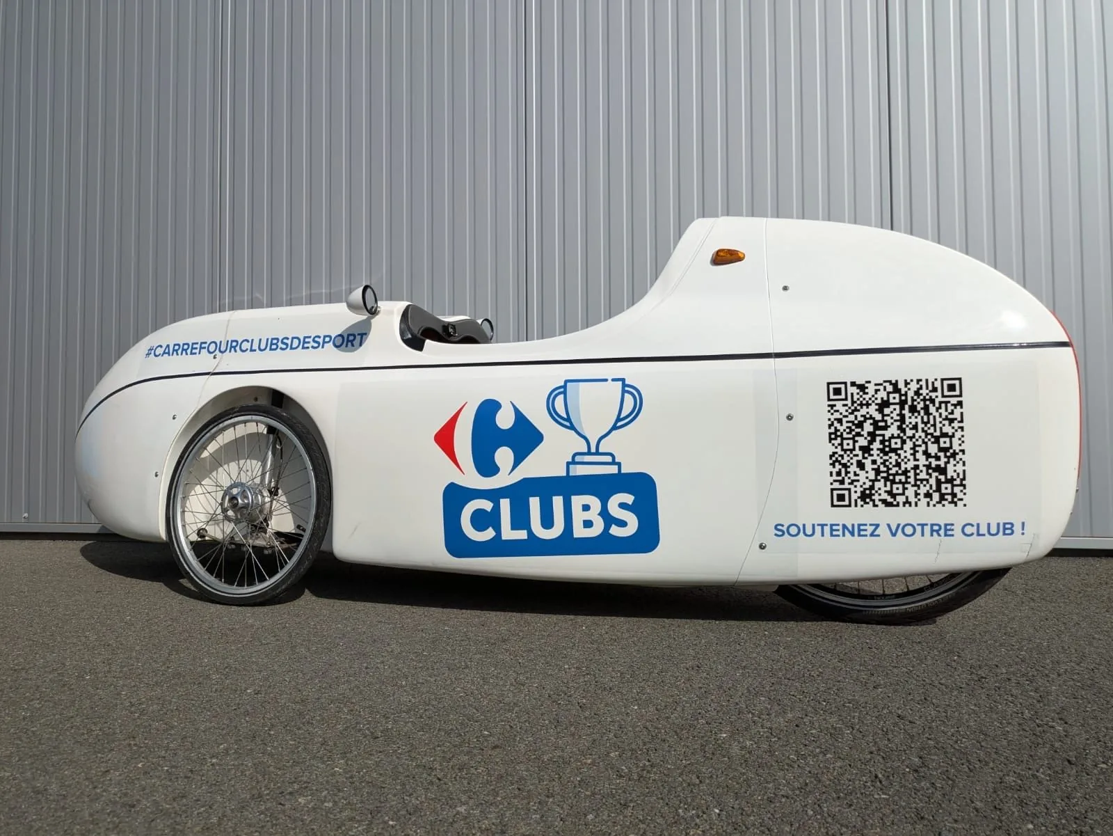 Vélo caréné publicitaire de la régie Fitcar aux couleurs Carrefour Clubs de Sport — roadshow
